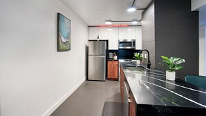 A modern kitchen with stainless steel appliances, a marble countertop, and a minimalist design. - Cozy 2-bedroom condo in terrific Old Town Scottsdale with WiFi, AC, and patio (Scottsdale)