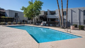 A swimming pool with a clear blue water, surrounded by a concrete deck and a metal fence. - Cozy 2-bedroom condo in terrific Old Town Scottsdale with WiFi, AC, and patio (Scottsdale)