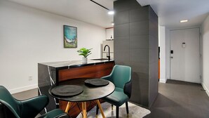 A modern kitchen with a black marble countertop, a sink, and a potted plant. There is a dining area with two chairs and a round table. - Cozy 2-bedroom condo in terrific Old Town Scottsdale with WiFi, AC, and patio (Scottsdale)