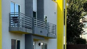 Un edificio moderno de dos pisos con un balcón, una puerta y una ventana.