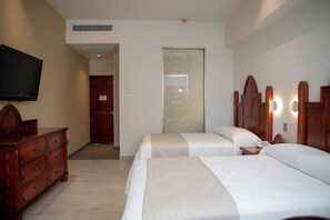 A hotel room with two beds, a TV, a wooden dresser, and a door leading to another room. - Vallarta Live Hotel (Puerto Vallarta)