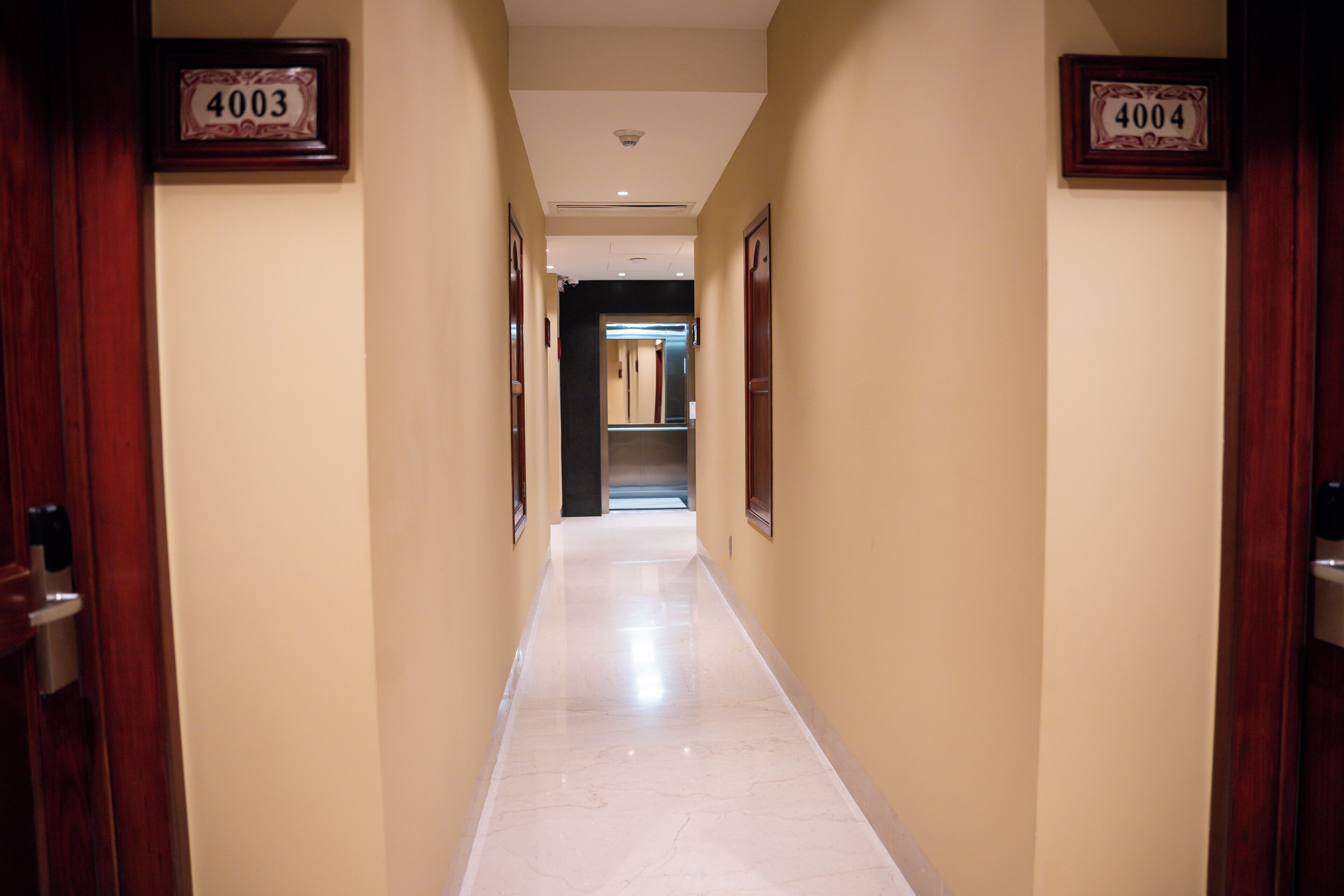 A hallway with numbers 4003 and 4004 on the walls, leading to a door at the end.