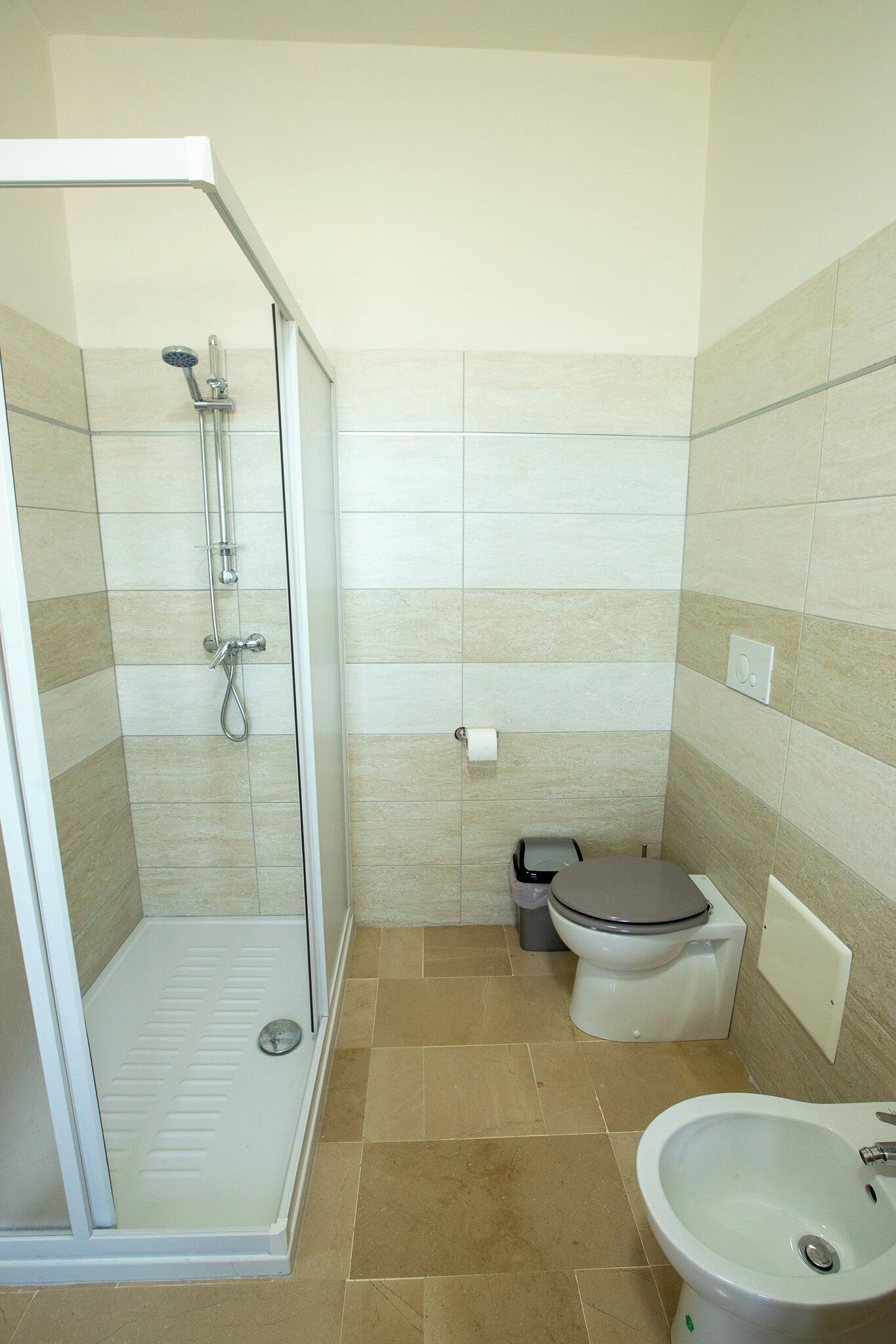 A bathroom with a shower, toilet, and sink.