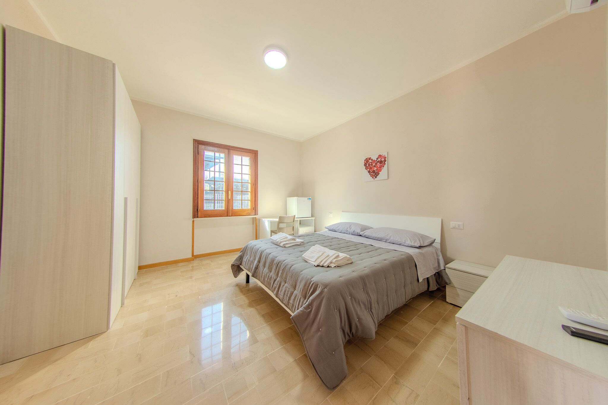 A bedroom with a bed, bedside table, and a wardrobe.
