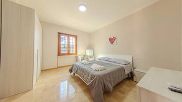 A bedroom with a bed, bedside table, and a wardrobe.