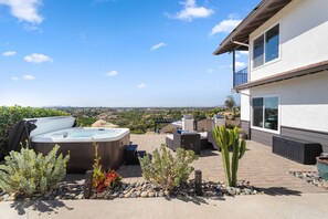 Eine Terrasse mit Whirlpools, Gartenmöbeln und einer Kakteenpflanze.