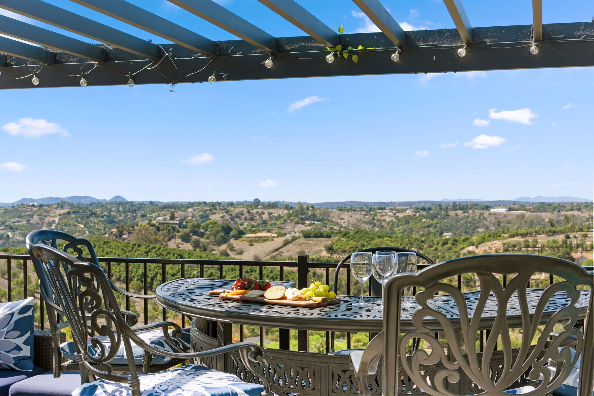 Terraço com mesa posta para refeição, com vista para uma paisagem deslumbrante.