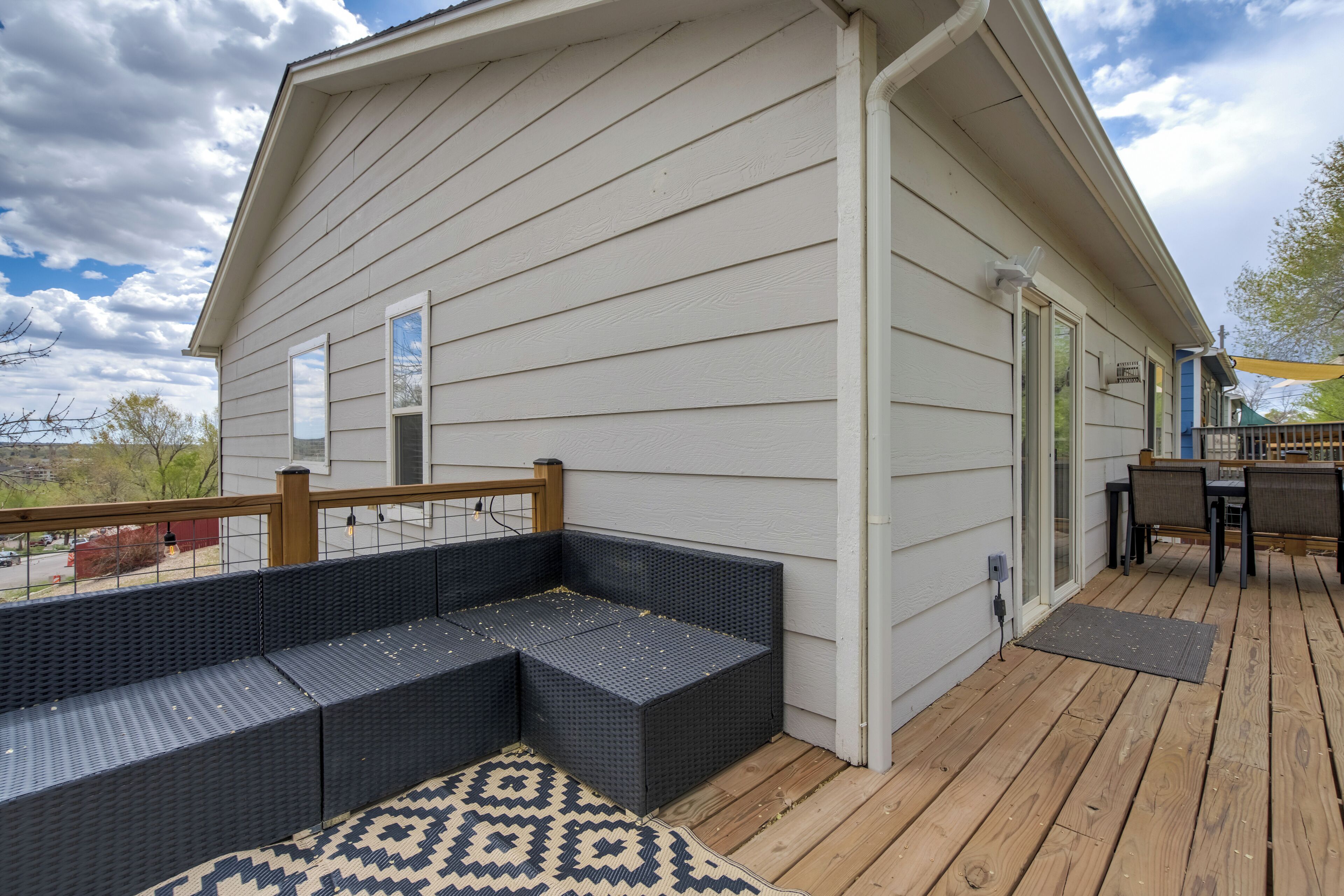 A covered deck with a built-in seating area and a wooden table.