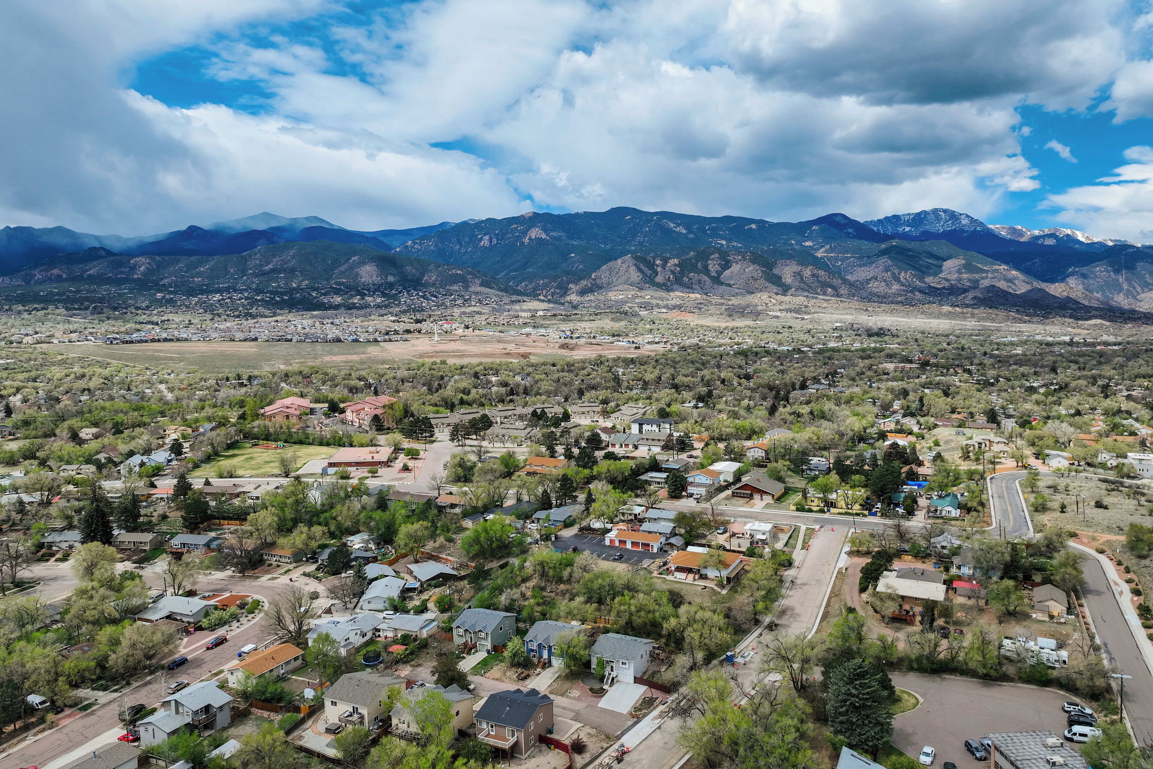 A residential area with houses, roads, and mountains in the background.