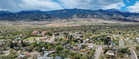 A residential area with houses, roads, and mountains in the background.