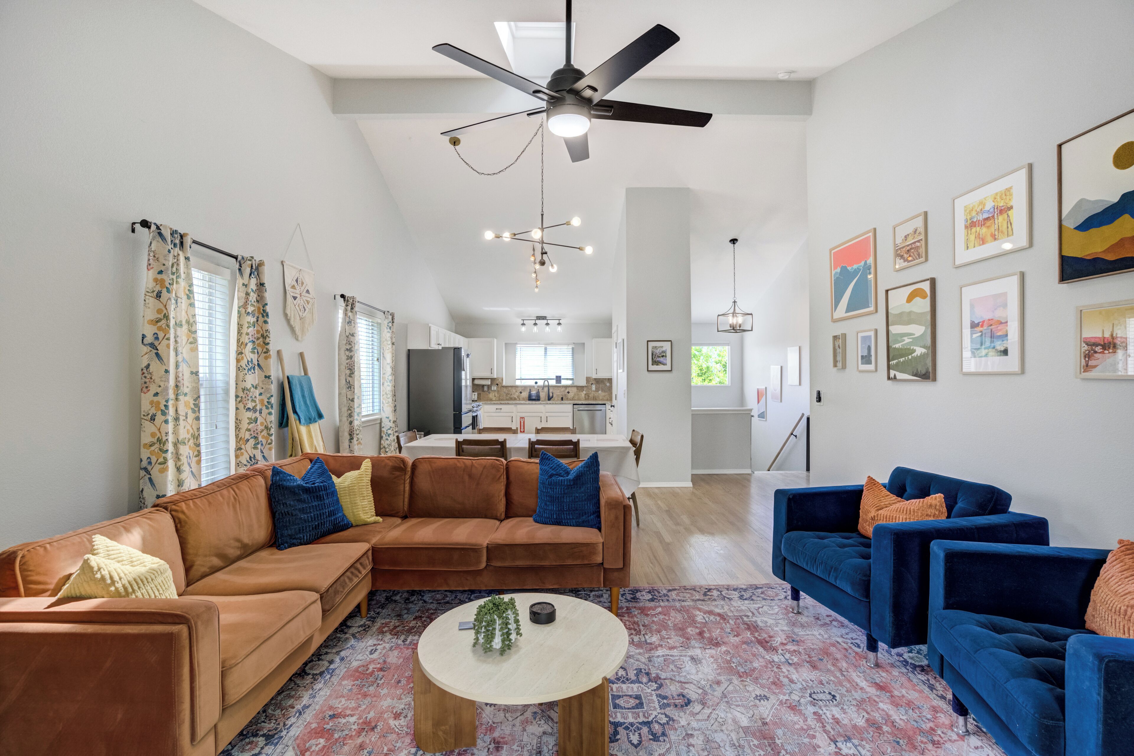 A spacious living room with a sectional sofa, a blue armchair, and a coffee table.