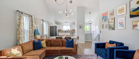 A spacious living room with a sectional sofa, a blue armchair, and a coffee table.