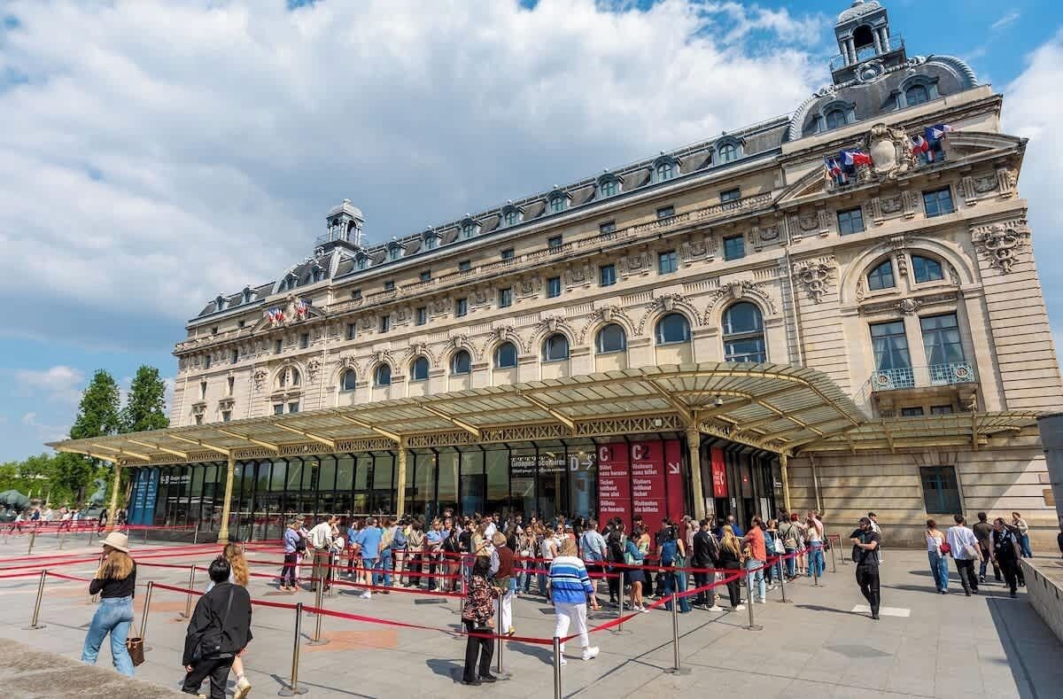 A historic building with a covered entrance and a crowd of people.