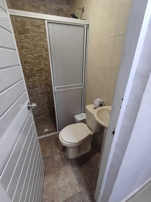 Een douche, handdoeken, zeep, toiletpapier