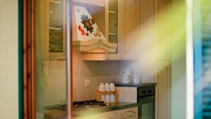 Une cuisine équipée d’une cuisinière à gaz, de meubles de rangement en bois et d’un crédence décorative.