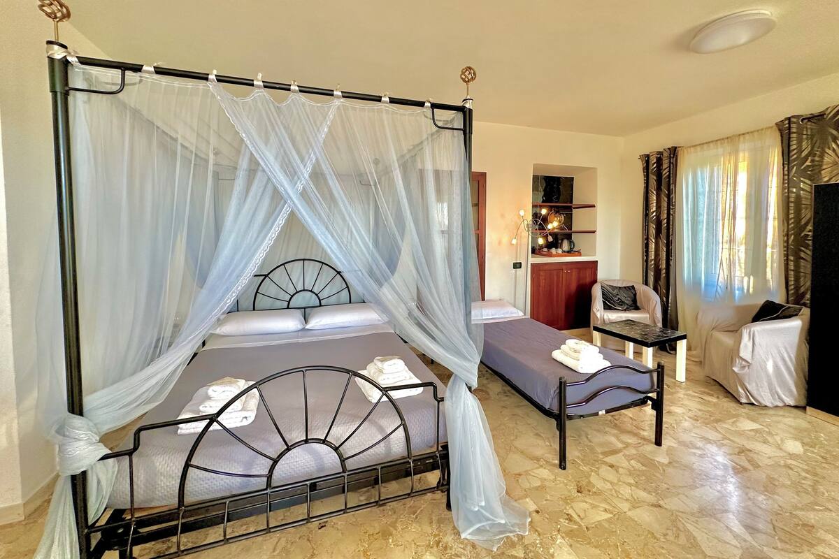 A room with a bed, a small table, a chair, and a desk.