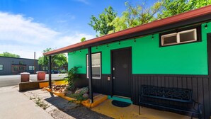 A small, single-story building with a green exterior and a black door. - Atomic #1 I Downtown I Historic I Trailer Parking (Moab)