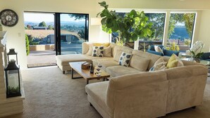 A living room with a large window, a sofa set, a coffee table, and a potted plant. - Kiler Ranch House is a charming 3-bedroom house that is ideal for a weekend away (Paso Robles)