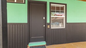 A house with a black door, a window with white framing, and a green wall. - Atomic #2 I Downtown I Historic I Trailer Parking (Moab)