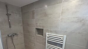 A modern bathroom with a shower, a built-in sink, and a towel rack. - Nice T2 on the little port of Sanary, Clim (Sanary-sur-Mer)