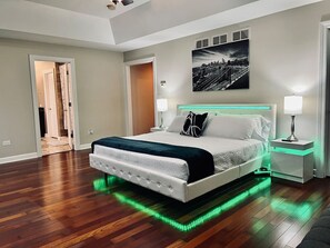Relax in this serene bedroom with a large bed, nightstands, and a stylish headboard.