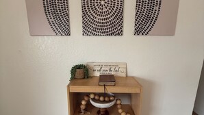 A wooden shelf with decorative items, a Bible, and a sign with a biblical quote. - Boho 3BR, 2BA Home in Colorado Springs Sleeps 6+ (Colorado Springs)