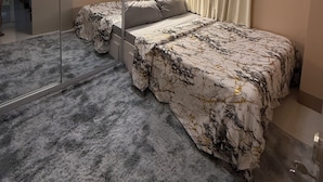 A modern bedroom with a bed, a wardrobe, a mirror, and an air conditioning unit. - Glamorous 2BR/1Bath/Wifi/Netflix/Heater/Washing/5starBnB (Pasay)
