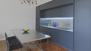 Una cocina moderna con una isla integrada, electrodomésticos de acero inoxidable y una araña.