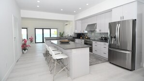 A modern kitchen with a central island, stainless steel appliances, and a bright, airy design.