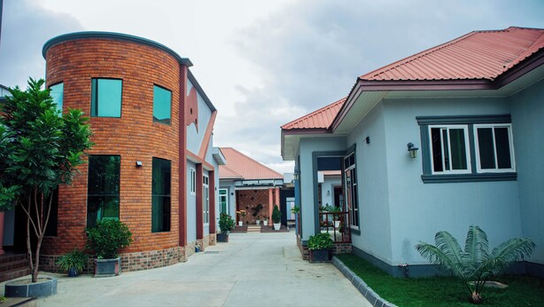 Un barrio residencial con casas modernas, un edificio curvo de ladrillo y un césped bien cuidado.