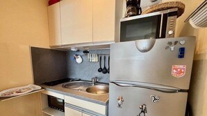 Une cuisine compacte équipée d’un évier, d’un four à micro-ondes et d’un réfrigérateur.