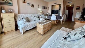 Un salon confortable avec un canapé, une table à manger et un coin cuisine.