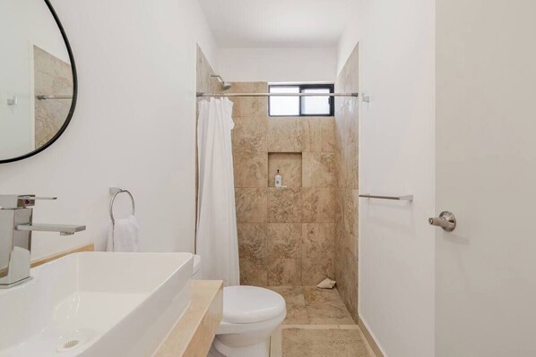 Un baño moderno con bañera, inodoro y ducha.