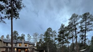 A two-story house with a stone exterior, a fire pit, and a playground in the yard.