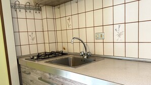 A kitchen with a stainless steel sink, a gas stove, and a tiled backsplash. - M421 - Marcelli, two-room apartment with patio 100m from the sea (Marcelli)