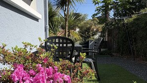 A garden with a lawn, potted plants, and outdoor furniture.
