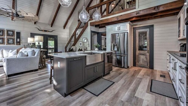 A spacious kitchen with a central island, stainless steel appliances, and a wooden staircase. - Toccoa Time - Riverside | Pet Friendly | Firepit | Pool table (Blue Ridge)