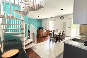 A modern kitchen with a dining area, a staircase, and a view of the outside. - CV013 - Cervia, wonderful penthouse with panoramic terrace (Cervia)