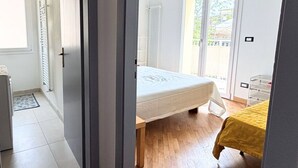 Ein Schlafzimmer mit Bett, Fenster und Heizkörper.