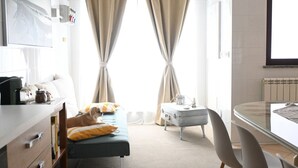 Une chambre d’hôtel avec un lit, un bureau, une chaise et une fenêtre avec des rideaux.