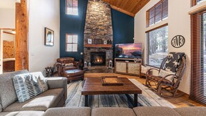 Un salón acogedor con chimenea de piedra, sofá de cuero y una mesa de centro de madera.