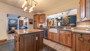 Una cocina amplia con armarios de madera, encimera de granito e iluminación moderna.