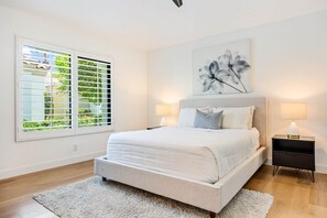 A bedroom with a large bed, two bedside tables, a window with blinds, and a wall-mounted artwork. - Golf Paradise: Fairway Views & Private Poolside (La Quinta)