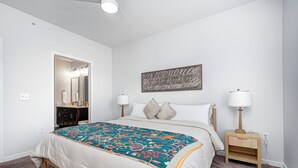 A bedroom with a bed, two bedside tables with lamps, a large mirror, and a wall art piece. - Comfy Cozy - 2King bed/2bth Fishers (Fishers)