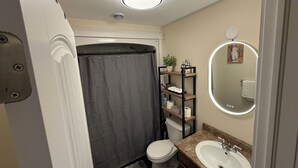 A compact bathroom with a shower, toilet, and sink.