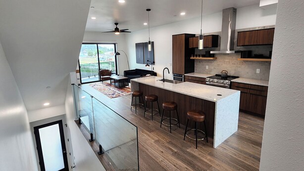 A modern kitchen with a central island, bar stools, and a view to the outside. - Hot Tub! Dog Friendly! Short Walk to Sandy Beach! (Waldport)