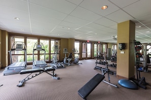 A gym with treadmills, weight machines, and dumbbells.