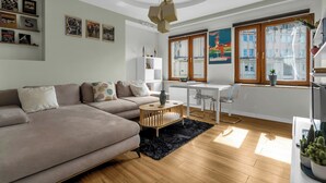 Un salon moderne avec un canapé, une table basse et un coin repas comprenant une table et des chaises blanches.