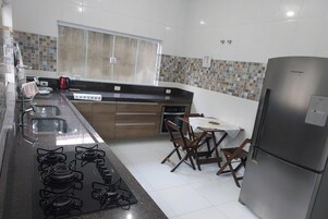 Frigorífico grande, horno, placa de cocina y utensilios de cocina