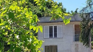 A two-story house with a car parked in front. - Recanto Ingles (Caraguatatuba)